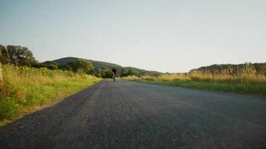 Güzel ve huzurlu bir bisiklet manzarası sakin ve sakin bir kır yolunda, çevresi bereketli doğayla çevrili.