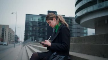 Şehir caddesinde yürürken cep telefonu kullanan bisikletli güzel genç kadının arka görüntüsü. Halk yaşam tarzı konsepti