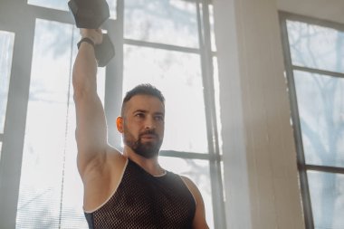 Formda ve güçlü bir adam halterle ağırlık kaldırma egzersizi yapıyor.