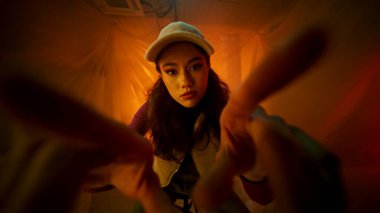 Entrika dolu, güzel aydınlatılmış bir yerde genç bir kadının büyüleyici yakınlaşması.