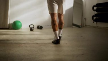Atletik bir birey spor salonunda yoğun bir antrenmana hazırlanıyor.