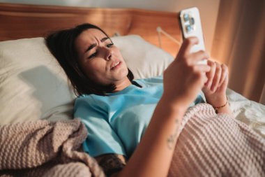 Bir kadın telefonuna bakar, şaşkınlık ve derin entrikalarla dolu bir anı gözler önüne serer.