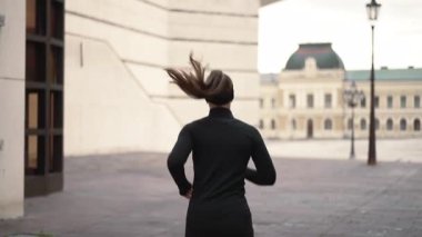 Zarif atletik kıyafetlerle koşan bir kadının büyüleyici hareketinin tadını çıkarın.