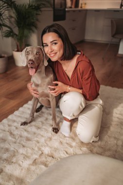 Şık ve güzel bir evde, bir kadın ve sevgili köpeği arasında neşeli bir an paylaşılır.