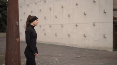 Modern şehir ortamında enerjik bir şekilde koşan bir kadının dinamik ve büyüleyici çekimleri.