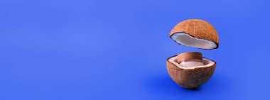 Cam kavanozda hindistan cevizi kreması ve ikiye bölünmüş taze hindistan cevizi ve izole edilmiş mavi arka planda uçmak. Cam bir kapta retinol ile kozmetik nemlendirici. Doğal güzellik organik nemlendirici krem..