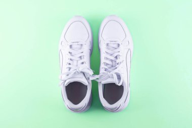 Pair of trendy white sneakers on light pink background, flat lay. Space for text