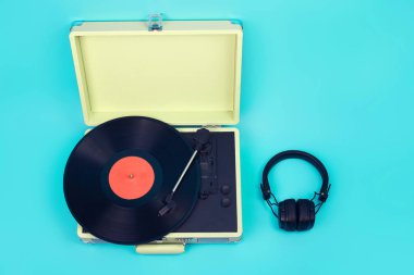 Kulaklıklı vintage turntable, izole edilmiş mavi arka planda üst görünüm