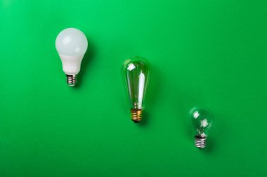 Öncü lamba ya da parlak lamba, Edie Lanp izole edilmiş yeşil arka planda. Düz yatıyordu. Ekolojiyi kavra, dünyayı kurtar, fikri, enerjiyi, ekonomiyi, tasarrufu. Dünya günü. Akıllı alışveriş, satış, ama...