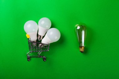 Alışveriş arabasında öncü lamba ya da izole yeşil arka planda parlak lamba. Düz yatıyordu. Ekolojiyi kavra, dünyayı kurtar, fikri, enerjiyi, ekonomiyi, tasarrufu. Dünya günü. Akıllı alışveriş, satış, ama...