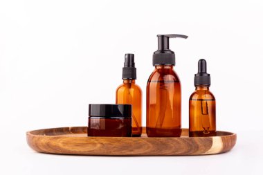 Kozmetik ambalajı. Beyaz arka planda izole edilmiş ahşap bir tepside farklı kozmetik krem ya da serum setleri. Boş ambalaj. Doğal güzellik spa ürünü konsepti. Çok güzel. Alaycı.