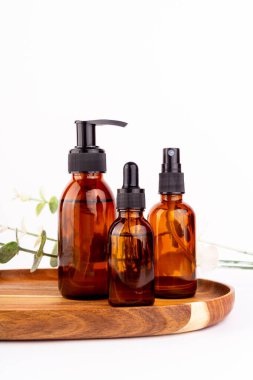 Yüz nemlendirici kremi, serum kehribar cam şişede gerekli yağ ve beyaz arka planda izole edilmiş. Düz yerde, üst tarafta. Cilt ve vücut bakımı güzellik ürünleri