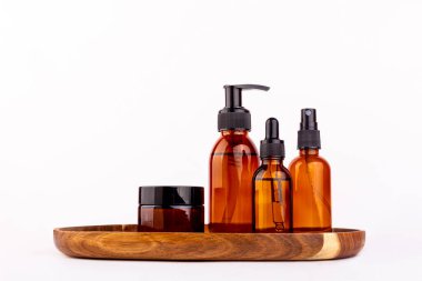 Kozmetik ambalajı. Beyaz arka planda izole edilmiş ahşap bir tepside farklı kozmetik krem ya da serum setleri. Boş ambalaj. Doğal güzellik spa ürünü konsepti. Çok güzel. Alaycı.