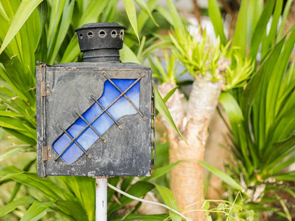 A navigation lamp with arrows to guide the way made of old iron, blue. Located in a public park