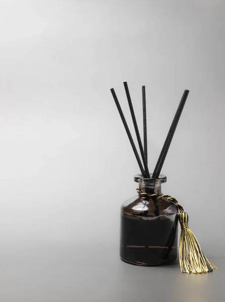 long black fragrant sticks one by one In a luxury opaque glass bottle with essential oils to spread the fragrance gray background There is a text area.