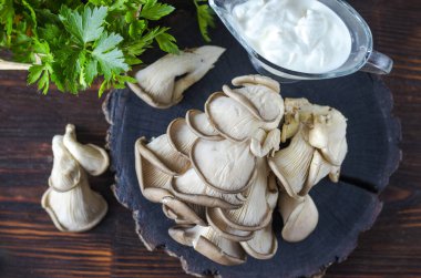 Taze pleurotus mantarı. Masadaki tahta tahtada taze istiridye mantarları.