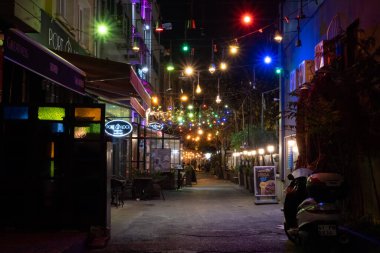 Karaky 'deki arka sokak ışıklarıyla süslenmiş. Gece renkli ışıklarla süslenmiş karanlık sokak konsepti. Şık festival sokağı.