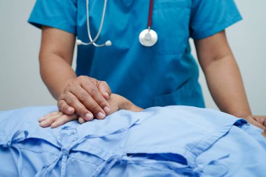 Doktor el ele tutuşuyor Asyalı yaşlı kadın hasta, hastanede yardım ve bakım.