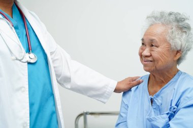 Doktor el ele tutuşuyor Asyalı yaşlı kadın hasta, hastanede yardım ve bakım.