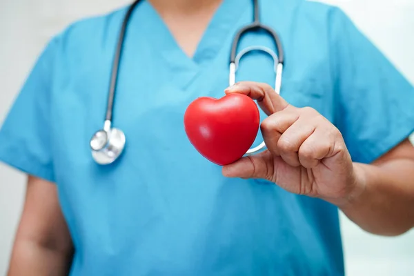 stock image Asian woman doctor holding red heart for health in hospital.