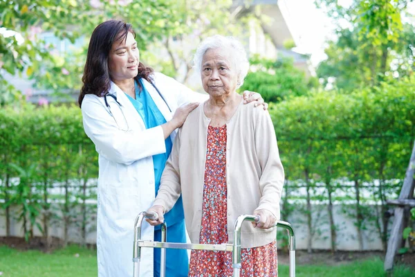 医生帮助亚洲老年残疾妇女与步行者在公园散步 医疗理念 — 图库照片