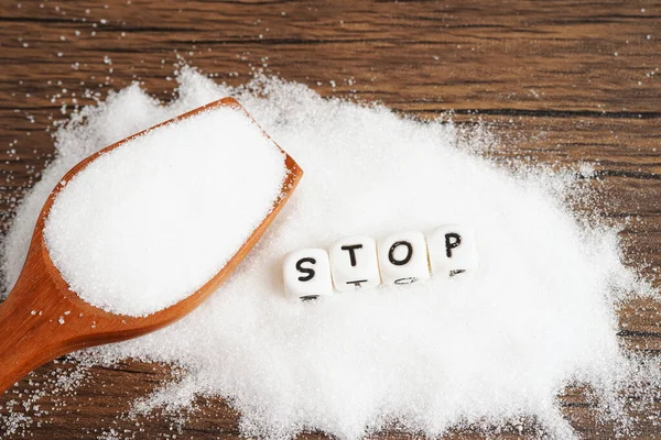 STOP, sweet granulated sugar with text, diabetes prevention, diet and weight loss for good health.