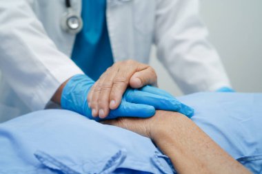 Doktor el ele tutuşuyor Asyalı yaşlı kadın hasta, hastanede yardım ve bakım.