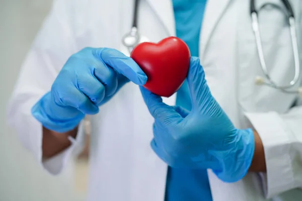 stock image Asian woman doctor holding red heart for health in hospital.