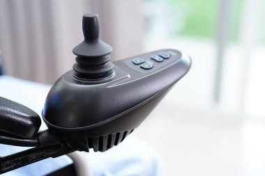 Parkta elektrikli sandalyede oturan Asyalı yaşlı kadın engelli hasta, tıbbi konsept..