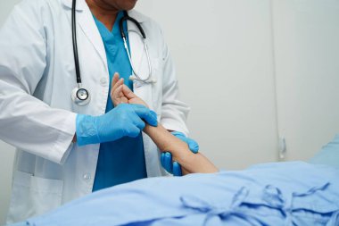 Doktor el ele tutuşuyor Asyalı yaşlı kadın hasta, hastanede yardım ve bakım.