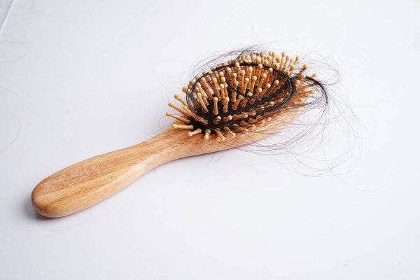 Hair loss fall with comb brush isolated on white background.