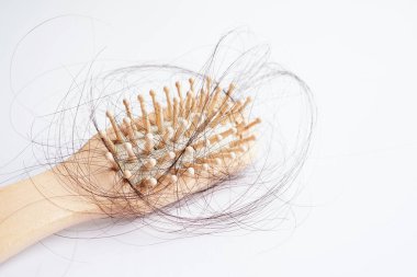 Tarak fırçasıyla beyaz arkaplanda saç kaybı.