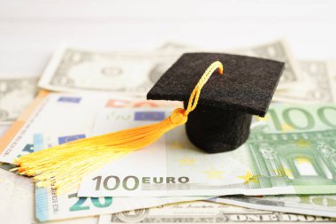 Avrupa ve ABD doları üzerindeki mezuniyet şapkası para, eğitim ücreti öğrenim öğrenimi öğretim konsepti.