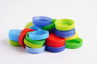 Plastik şişe kapakları beyaz arka planda geri dönüşüm için renklidir.