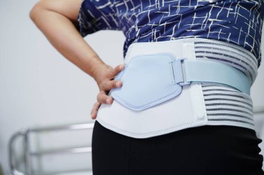 Esnek destek kemeri takan Asyalı son sınıf öğrencisi sırt ağrısını azaltabilir..