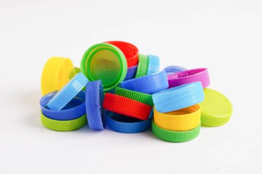 Plastik şişe kapakları beyaz arka planda geri dönüşüm için renklidir.