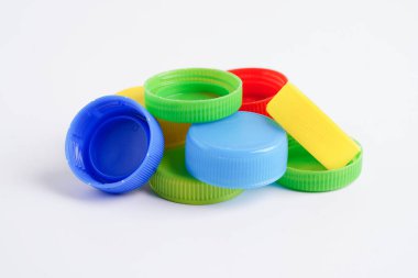 Plastik şişe kapakları beyaz arka planda geri dönüşüm için renklidir.