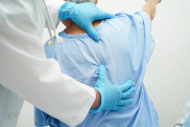 Steteskoplu Asyalı doktor hastanede yaşlı bir kadını kontrol ediyor, sağlıklı tıbbi konsept..