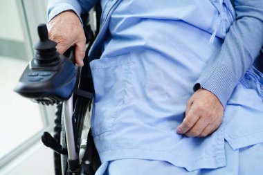 Parkta elektrikli sandalyede oturan Asyalı yaşlı kadın engelli hasta, tıbbi konsept..