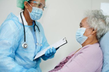 Doktor, Kovid Coronavirüs 'ü korumak için maske takan Asyalı yaşlı kadın hastayı kontrol et..
