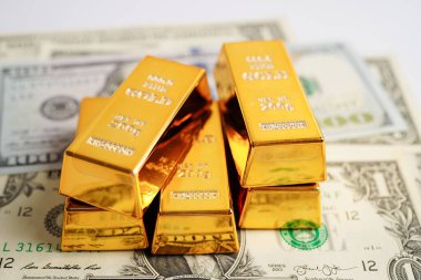 Gold bars on US dollar banknote money, finance trading investment business currency concept. 