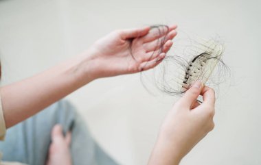 Asian woman have problem with long hair loss attach in her hand.