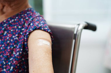 Koronavirüs aşısı olan Asyalı yaşlı kadın hasta.