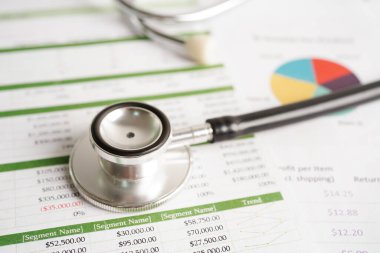 Çizelge ya da grafik kağıdı, Finansal, hesap, istatistik ve iş verileri medikal sağlık kavramı üzerine steteskop ve ABD doları banknotları.