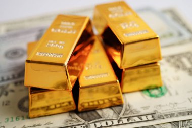 Gold bars on US dollar banknote money, finance trading investment business currency concept. 