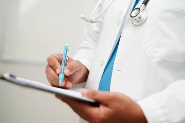 Doktor kontrol ediyor ve teşhis ilacını hastanedeki hastaların dosyalarına not ediyor..