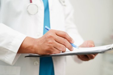 Doktor kontrol ediyor ve teşhis ilacını hastanedeki hastaların dosyalarına not ediyor..
