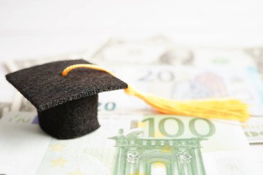 Avrupa ve ABD doları üzerindeki mezuniyet şapkası para, eğitim ücreti öğrenim öğrenimi öğretim konsepti.