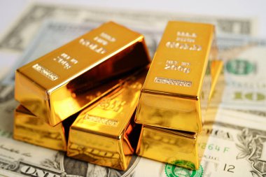Gold bars on US dollar banknote money, finance trading investment business currency concept. 