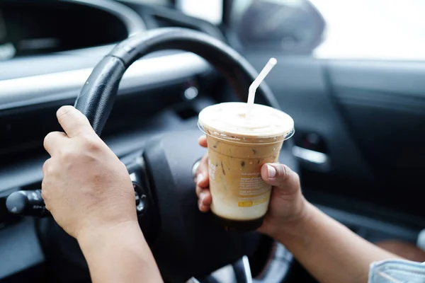 stock image Bangkok, Thailand - May 15, 2022 Asian woman driver hold ice coffee cup for drink in car, dangerous and risk an accident.